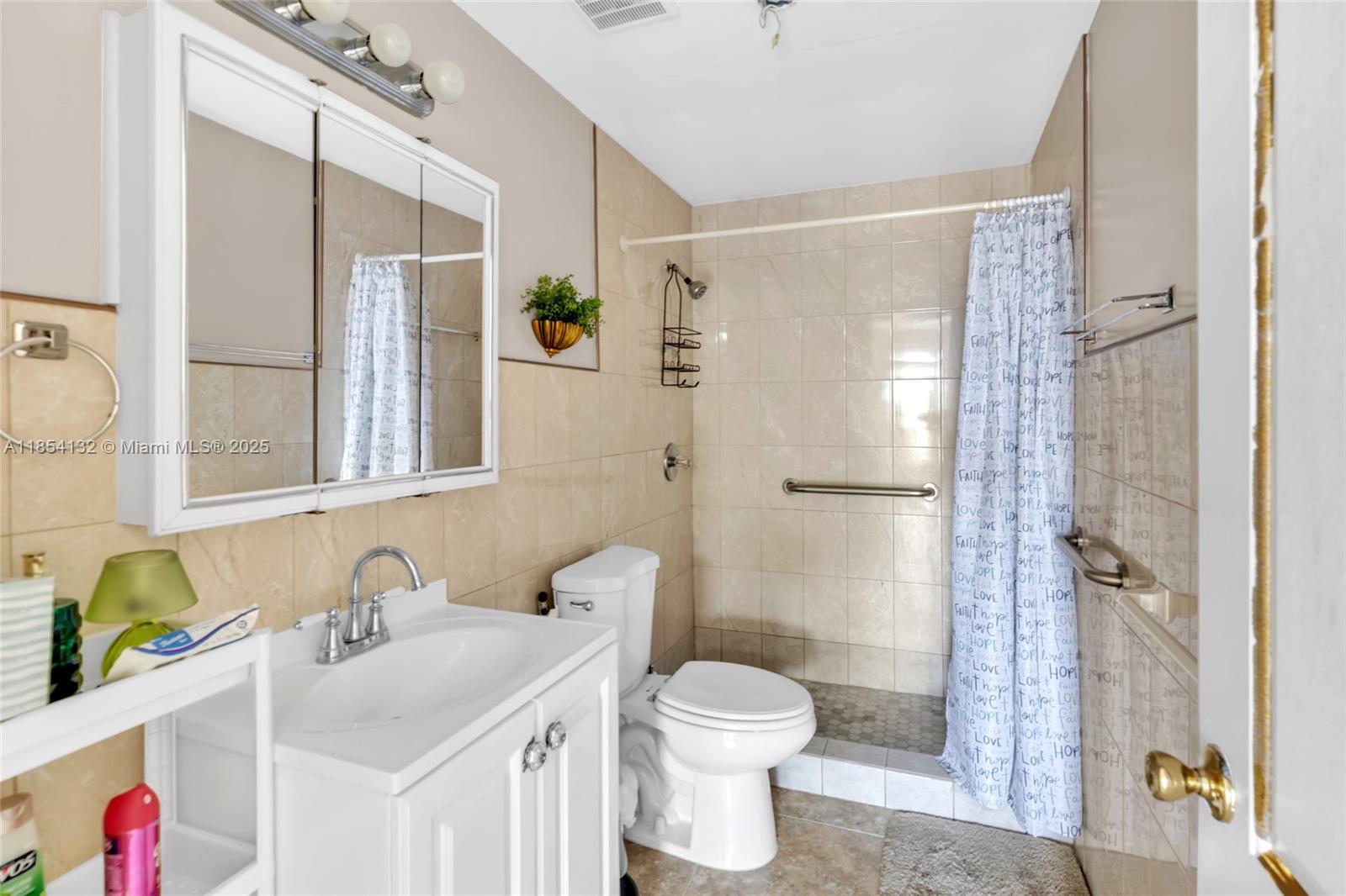 1855 West 62nd Street, Unit E306 Hialeah, FL 33012 - Photo 8 of 35 a bathroom with a sink toilet and shower