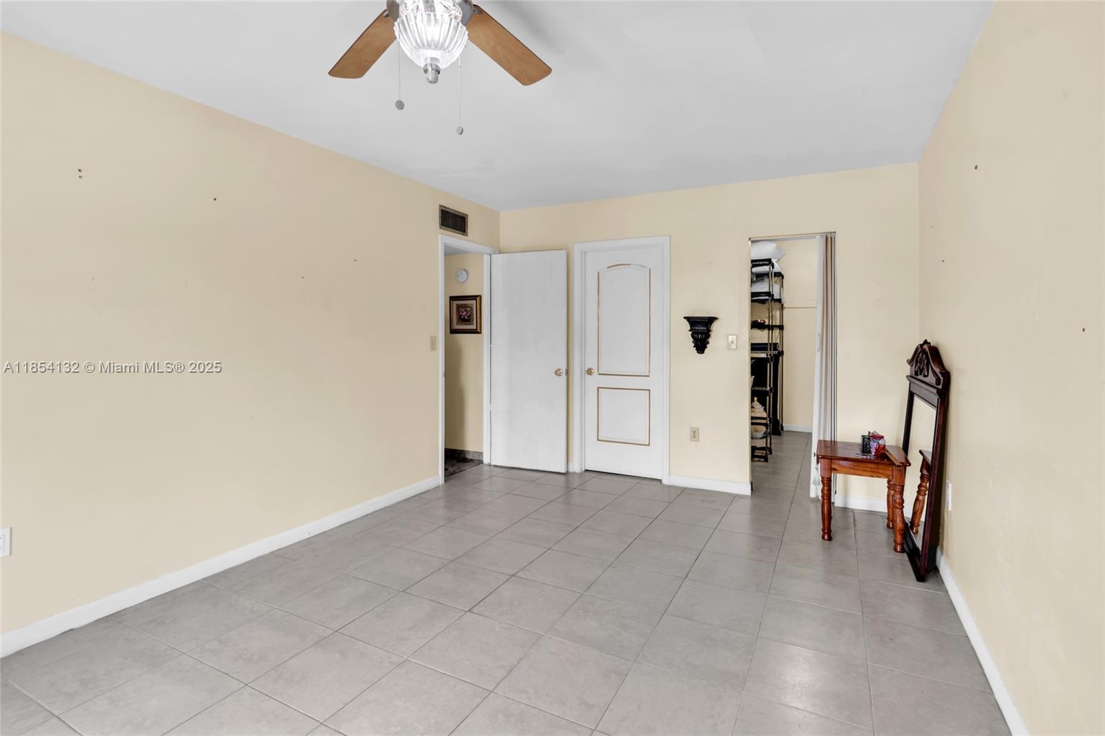 1855 West 62nd Street, Unit E306 Hialeah, FL 33012 - Photo 10 of 35 an empty room with closet and a ceiling fan