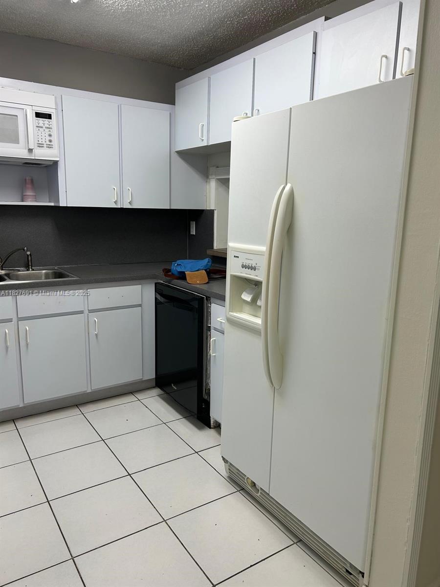 6125 West 20th Avenue, Unit 217 Hialeah, FL 33012 - Photo 4 of 16 a kitchen with stainless steel appliances a refrigerator sink and cabinets