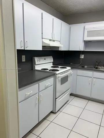 a kitchen with granite countertop white cabinets and white appliances