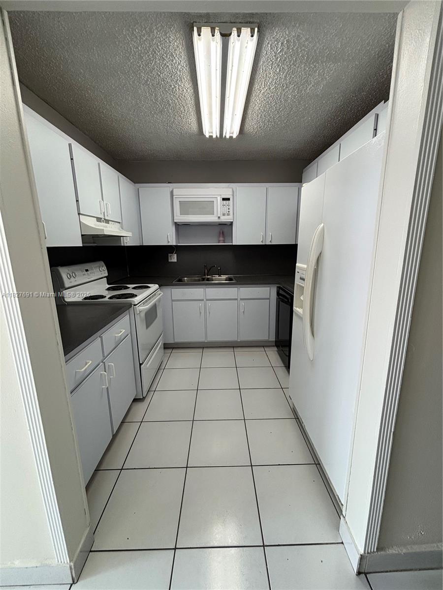 6125 West 20th Avenue, Unit 217 Hialeah, FL 33012 - Photo 7 of 16 a kitchen with cabinets and a stove top oven