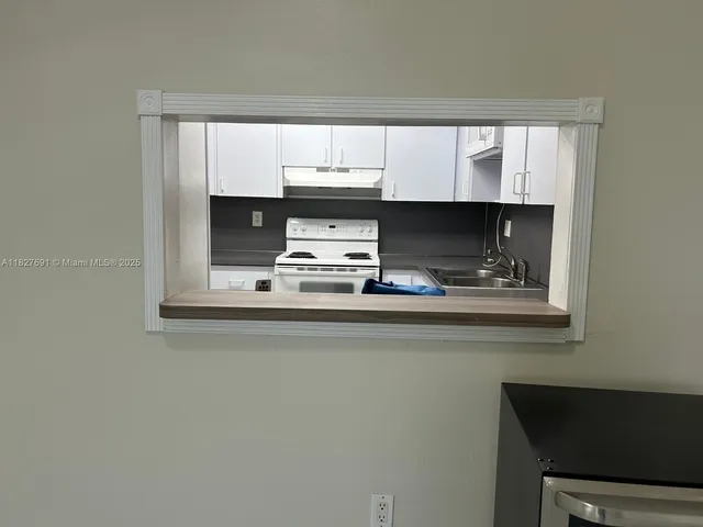 a kitchen with a sink a window and cabinets