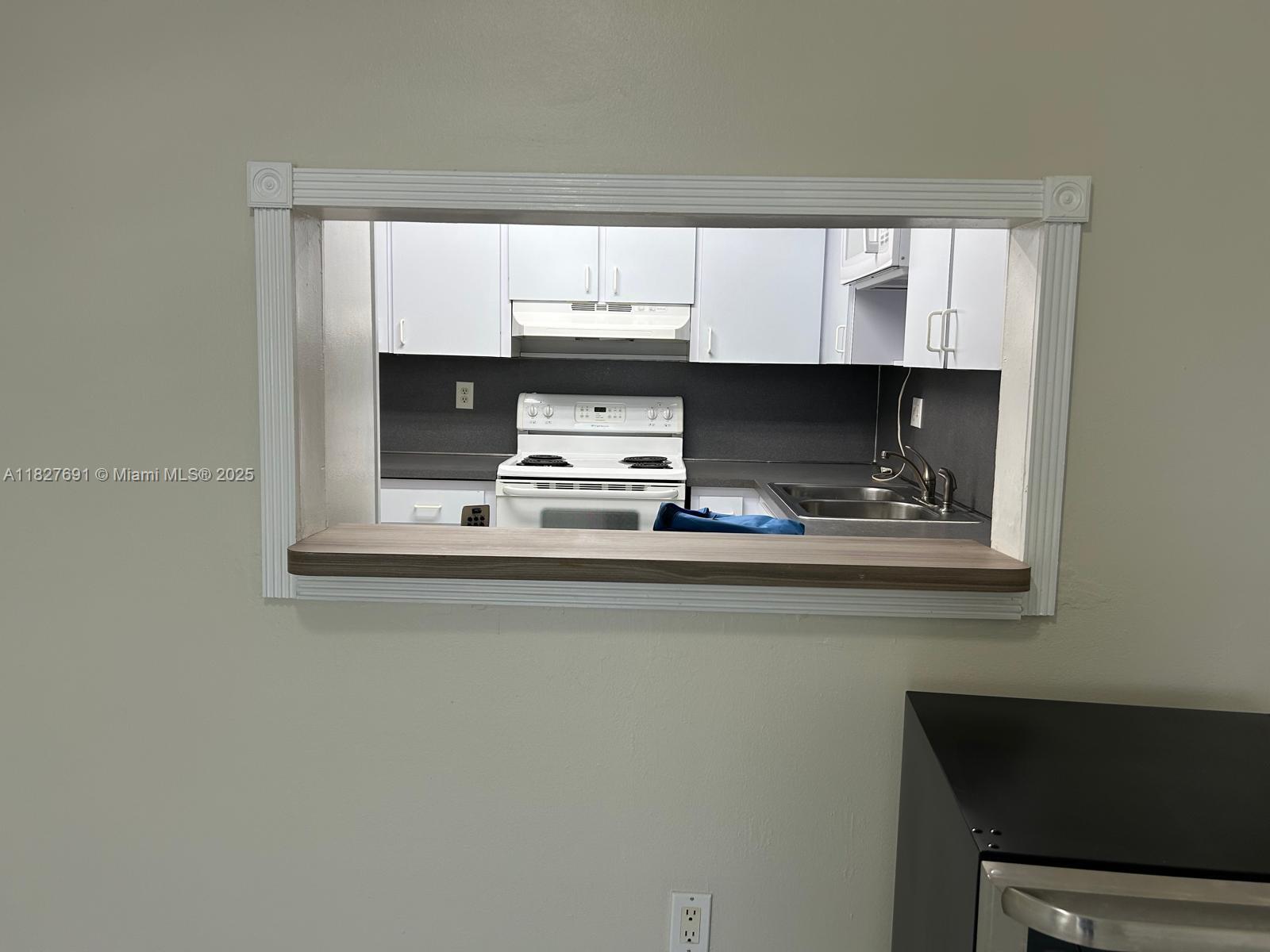 6125 West 20th Avenue, Unit 217 Hialeah, FL 33012 - Photo 8 of 16 a kitchen with a sink a window and cabinets