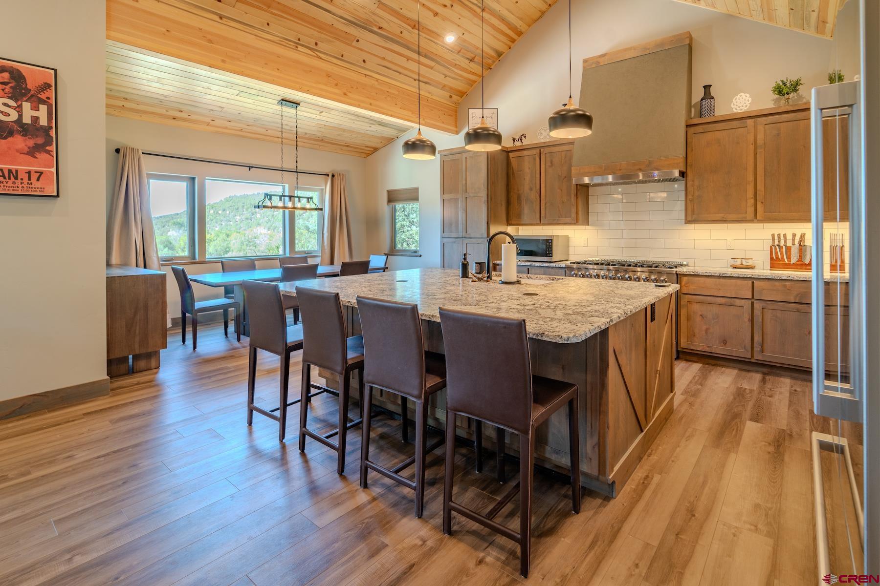 1700 Thoroughbred Road Durango, CO 81303 - Photo 12 of 45 a open kitchen with stainless steel appliances granite countertop a dining table chairs and wooden floor