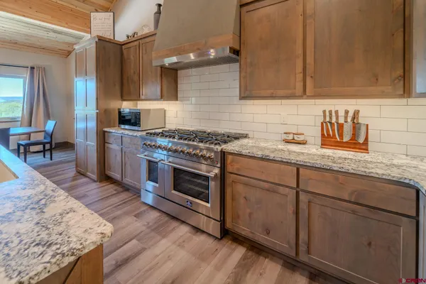 a kitchen with stainless steel appliances granite countertop a stove a sink and a refrigerator
