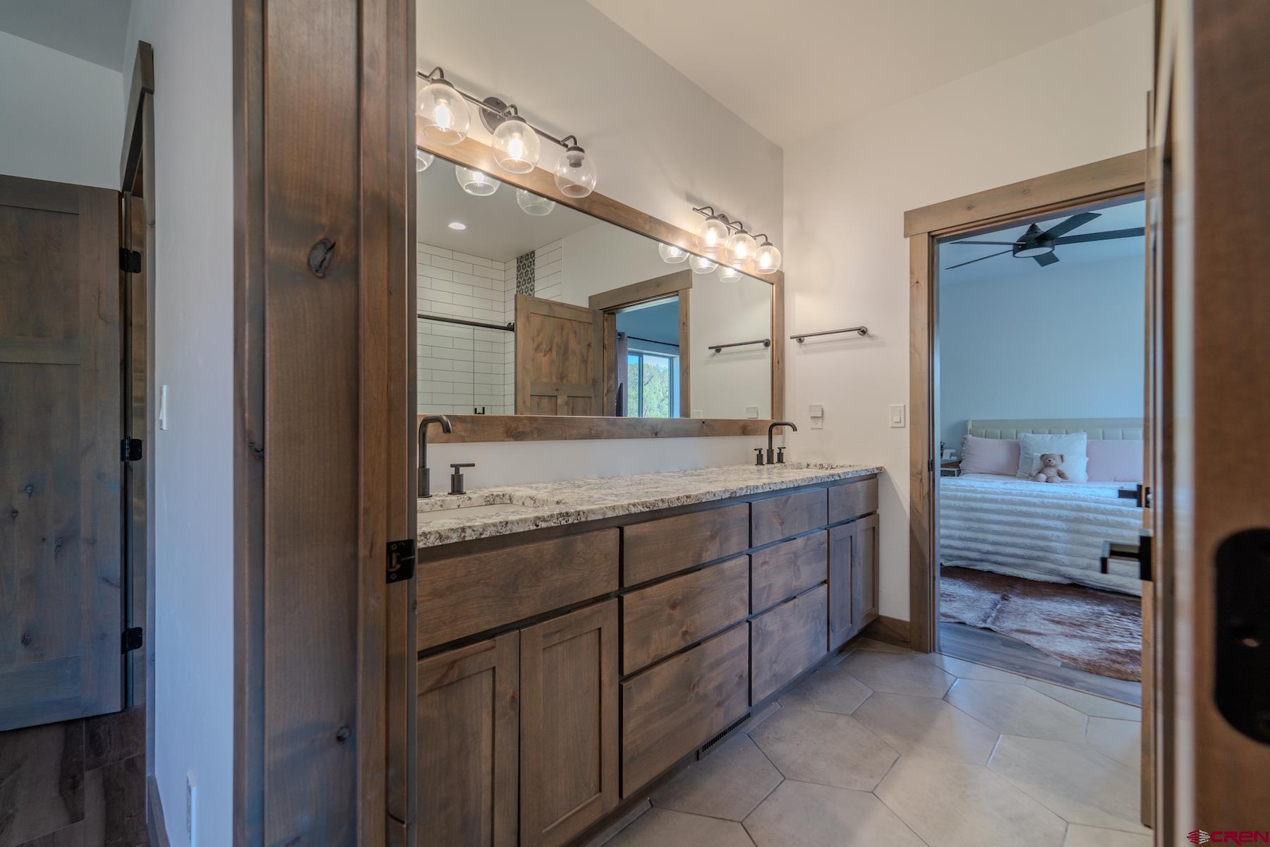 1700 Thoroughbred Road Durango, CO 81303 - Photo 29 of 45 a bathroom with a granite countertop double vanity sink and a mirror
