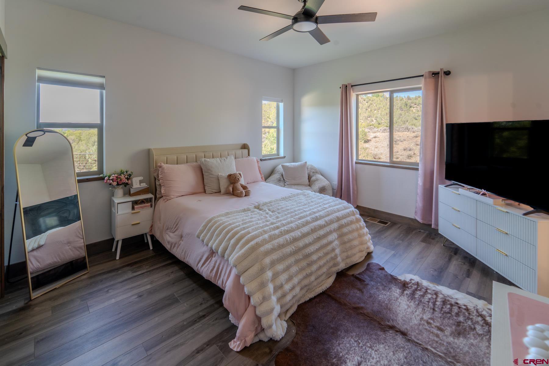 1700 Thoroughbred Road Durango, CO 81303 - Photo 31 of 45 a spacious bedroom with a bed and a flat screen tv