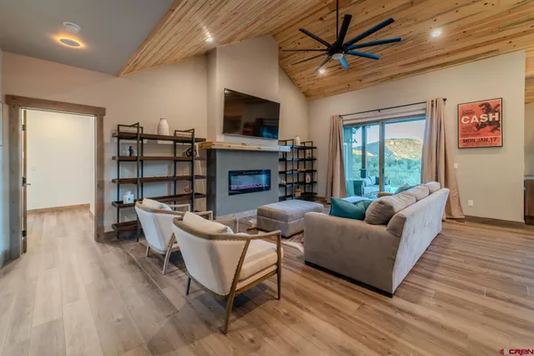 a living room with furniture a fireplace and a flat screen tv