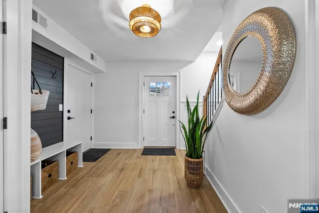 a view of a hallway with wooden floor and a potted plant