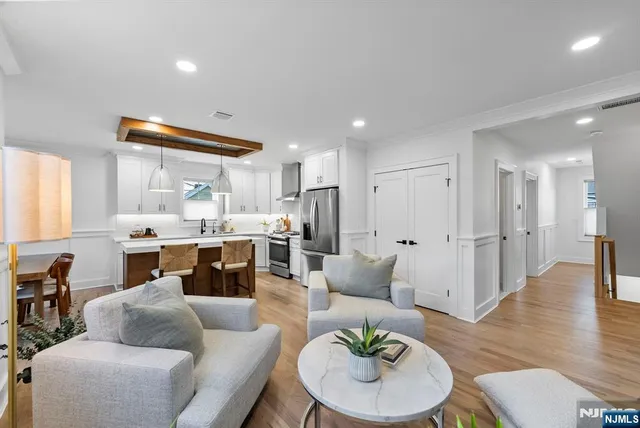 a kitchen with stainless steel appliances a table chairs refrigerator and cabinets