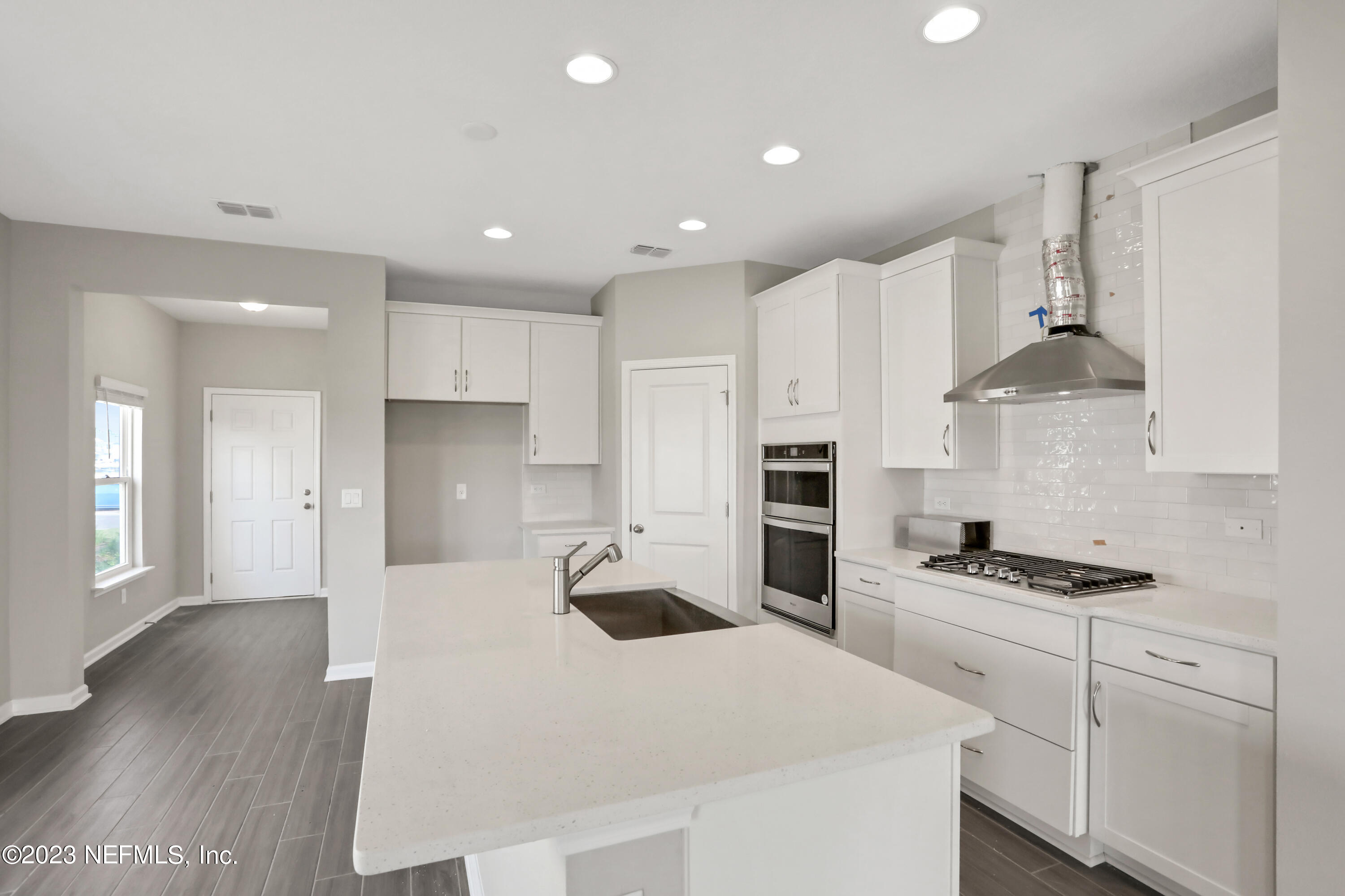 152 Torres Trace St. Augustine, FL 32095 - Photo 6 of 32 a kitchen with granite countertop a sink a stove a refrigerator and white cabinets