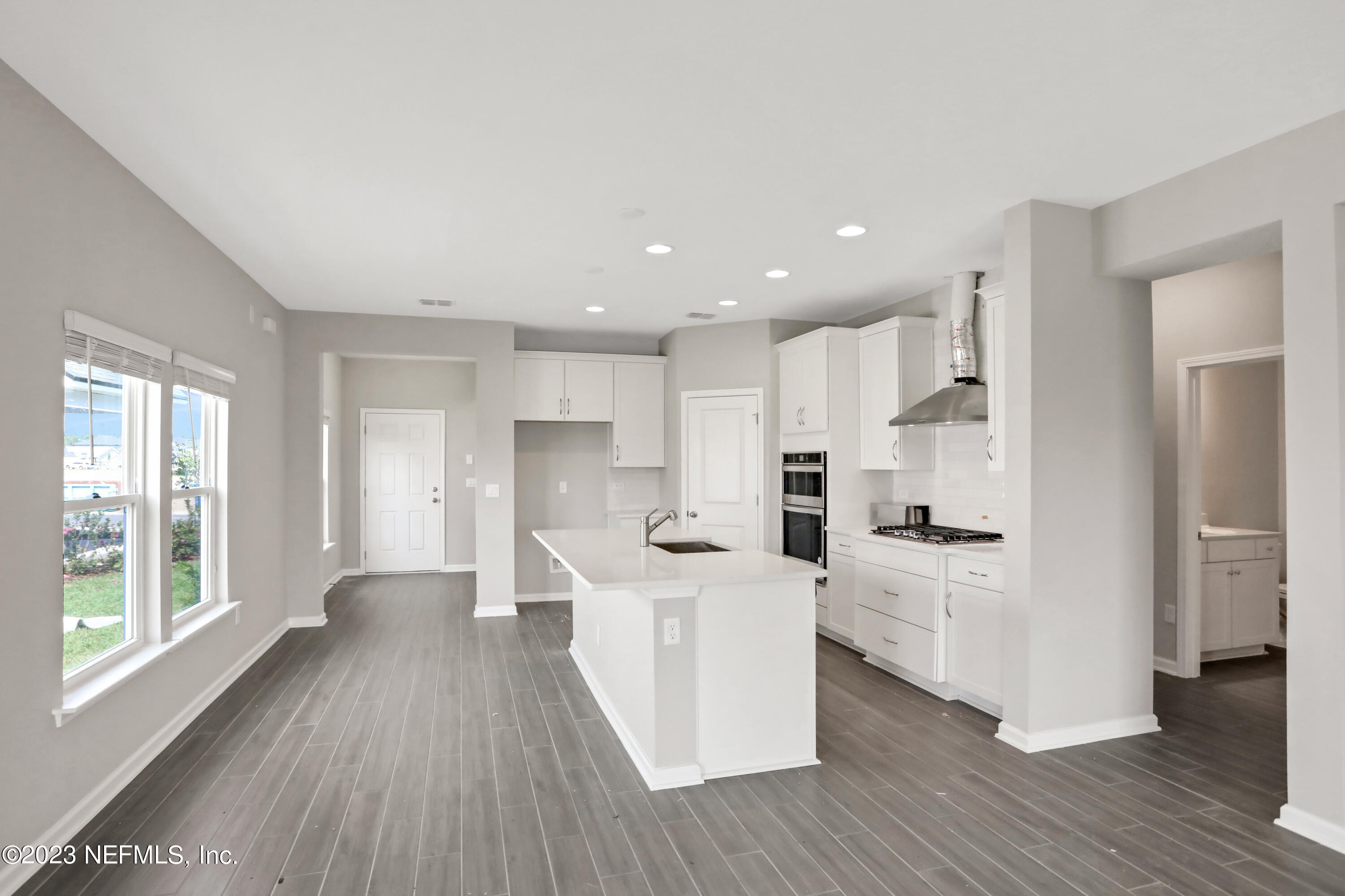 152 Torres Trace St. Augustine, FL 32095 - Photo 7 of 32 a view of a kitchen with cabinets stainless steel appliances wooden floor and a window
