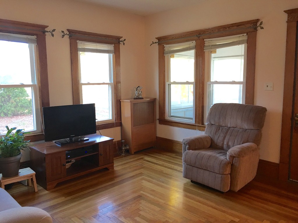 132 Windemere Street Springfield, MA 01104 - Photo 5 of 20 a living room with furniture and a flat screen tv with wooden floor