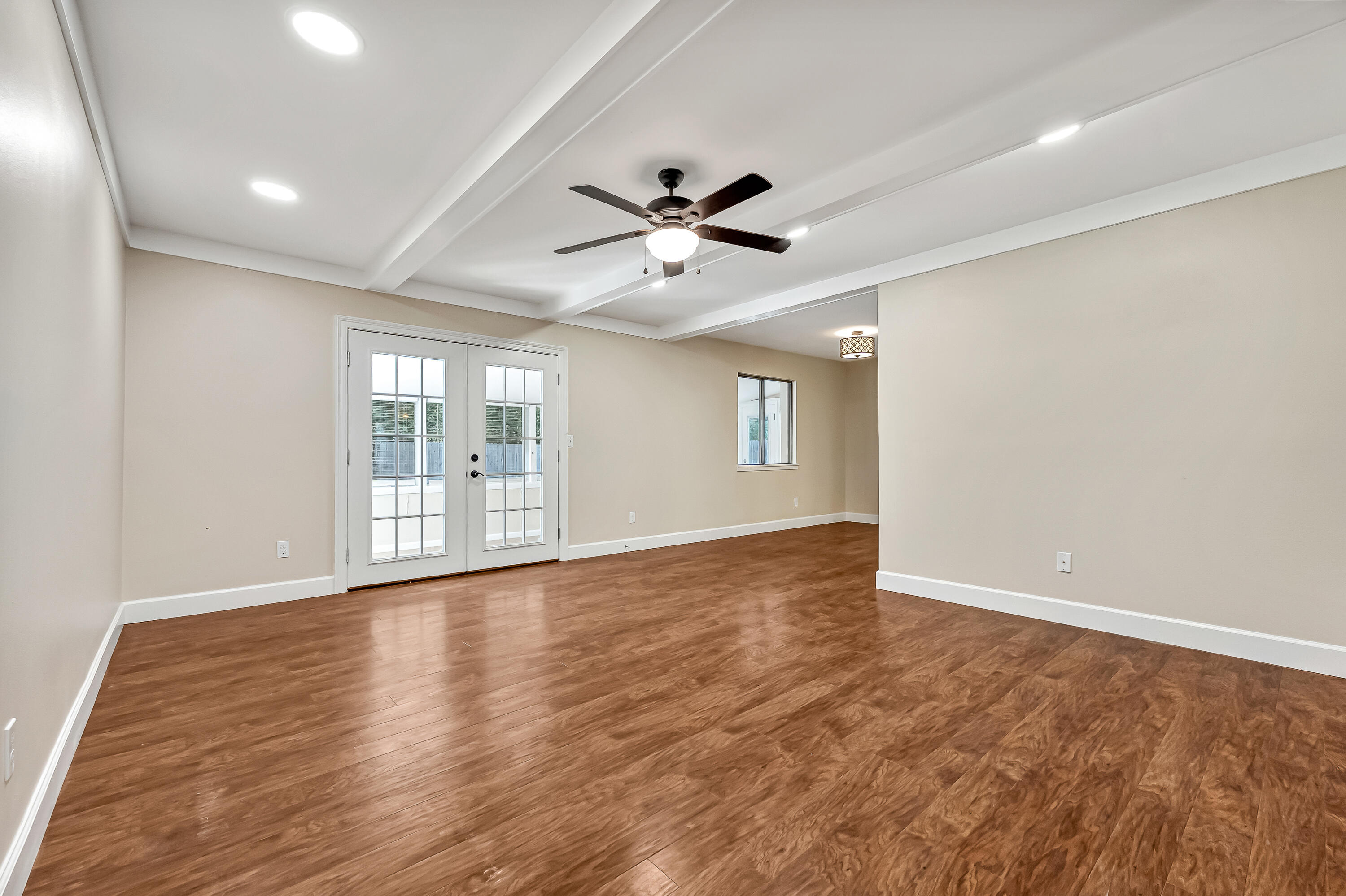 613 Caribbean Way Niceville, FL 32578 - Photo 3 of 27 a view of an empty room with a window and wooden floor
