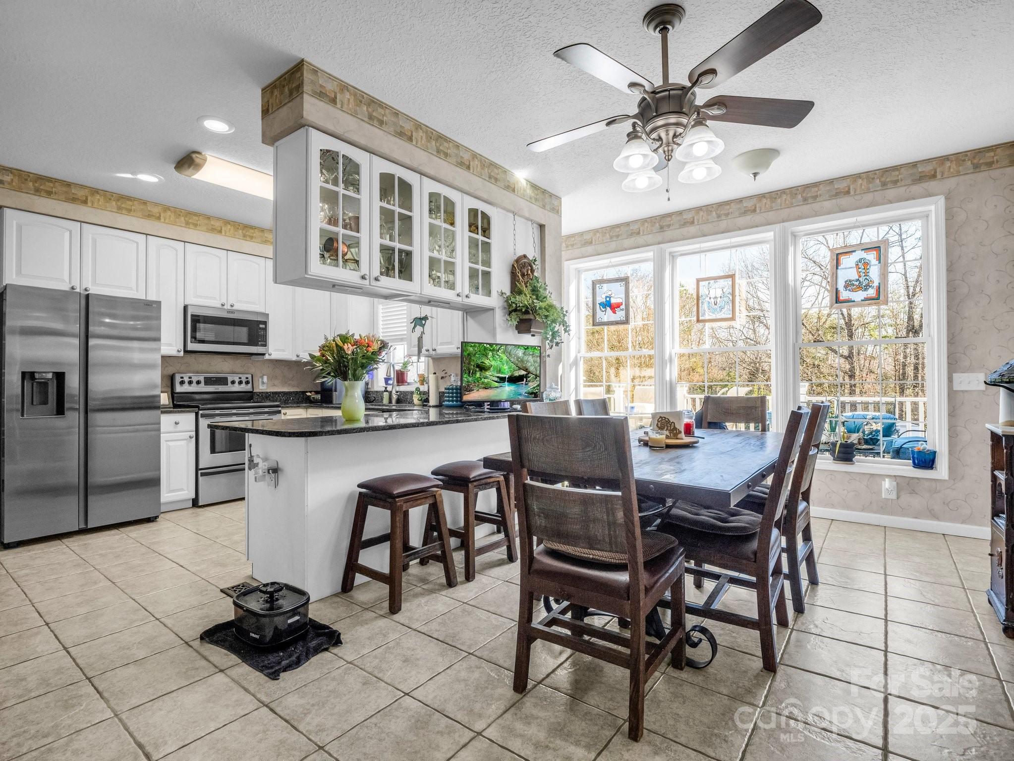 532 Harvey Logan Road Bostic, NC 28018 - Photo 27 of 48 a kitchen with stainless steel appliances kitchen island granite countertop a dining table chairs and a refrigerator