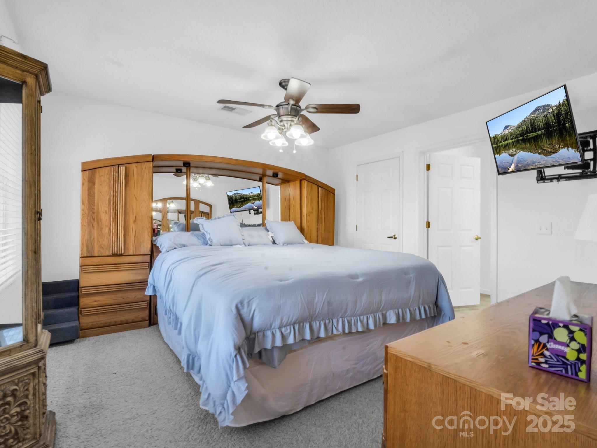 532 Harvey Logan Road Bostic, NC 28018 - Photo 42 of 48 a spacious bedroom with a bed and a chandelier
