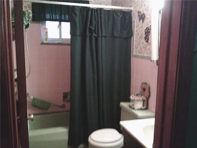 a bathroom with a toilet and a shower curtain