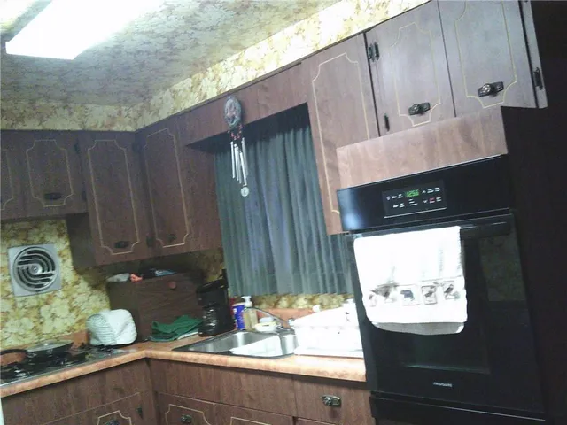 a kitchen with a sink a stove and a window
