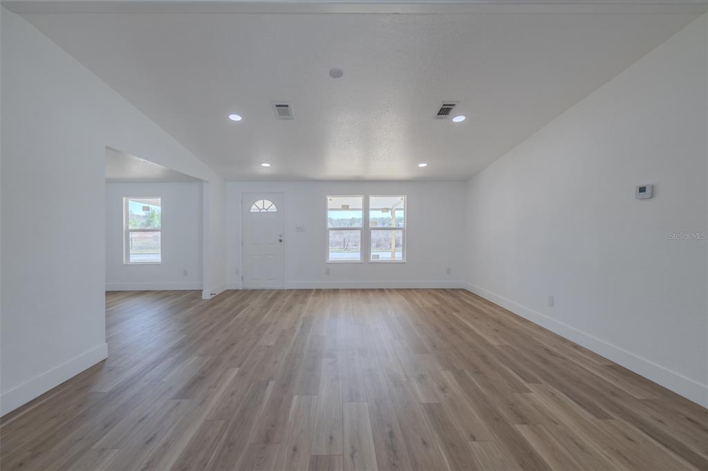 8301 Henry George Road Plant City, FL 33567 - Photo 11 of 51 an empty room with wooden floor and windows