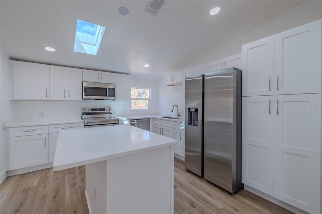8301 Henry George Road Plant City, FL 33567 - Photo 15 of 51 a kitchen with stainless steel appliances a refrigerator sink and microwave