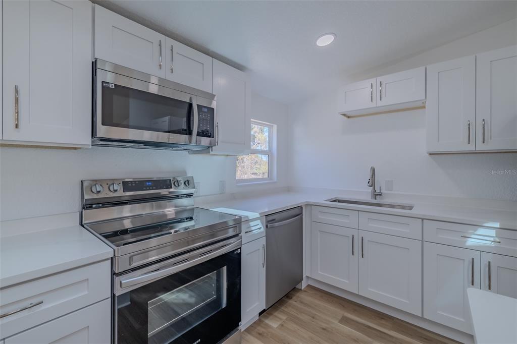 8301 Henry George Road Plant City, FL 33567 - Photo 16 of 51 a kitchen with cabinets stainless steel appliances and a sink