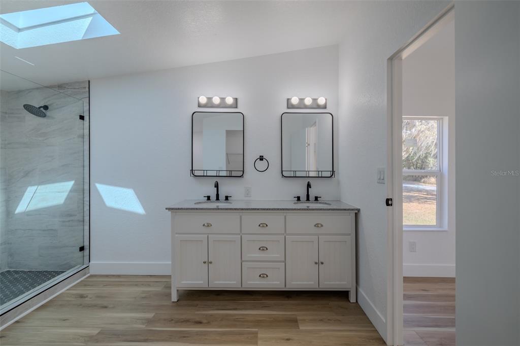 8301 Henry George Road Plant City, FL 33567 - Photo 26 of 51 a spacious bathroom with double vanity a mirror and a shower
