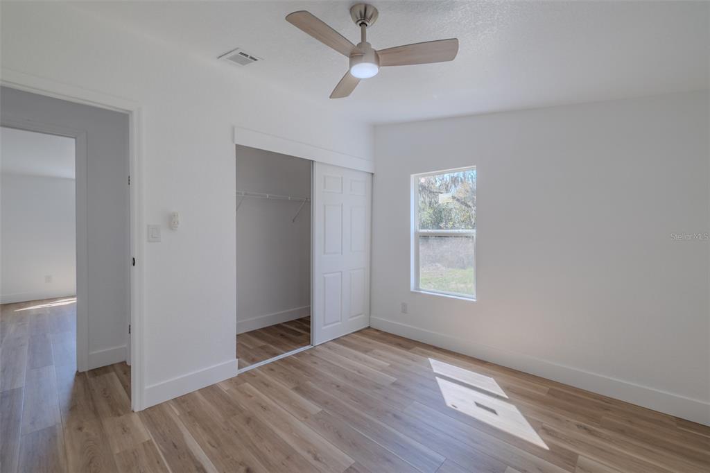8301 Henry George Road Plant City, FL 33567 - Photo 35 of 51 an empty room with wooden floor and windows