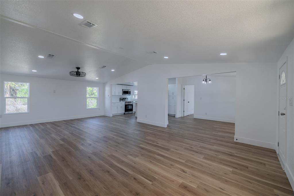 8301 Henry George Road Plant City, FL 33567 - Photo 7 of 51 an empty room with wooden floor and windows