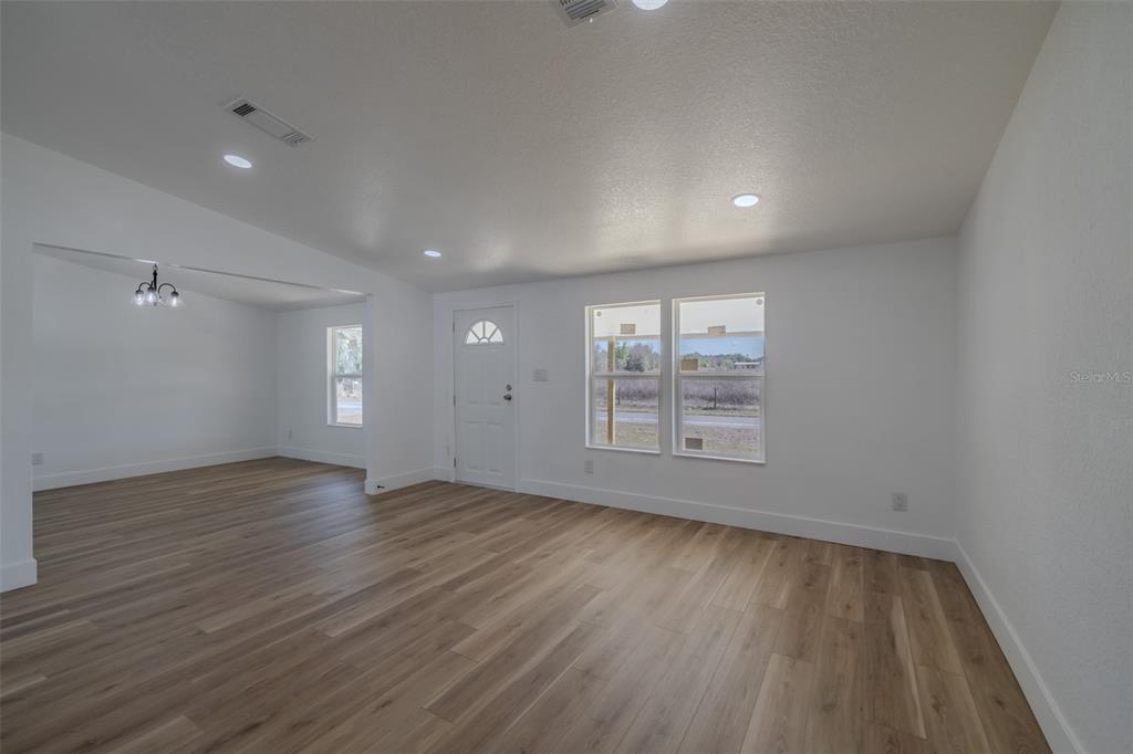 8301 Henry George Road Plant City, FL 33567 - Photo 8 of 51 an empty room with wooden floor and windows