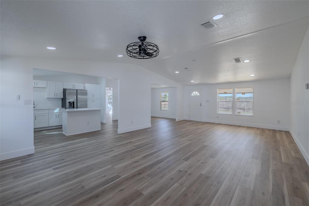 8301 Henry George Road Plant City, FL 33567 - Photo 10 of 51 an empty room with wooden floor and windows