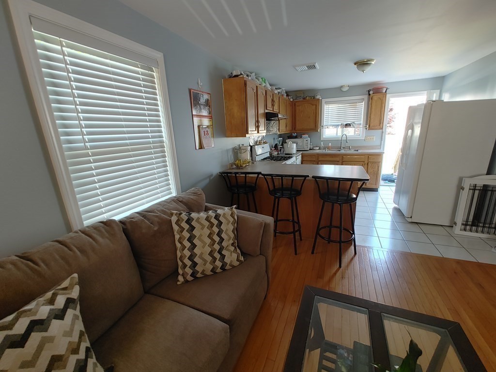 389 4th Street Fall River, MA 02721 - Photo 11 of 30 a living room with furniture two large window and wooden floor
