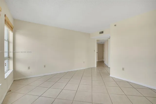 an empty room with white walls and tiles