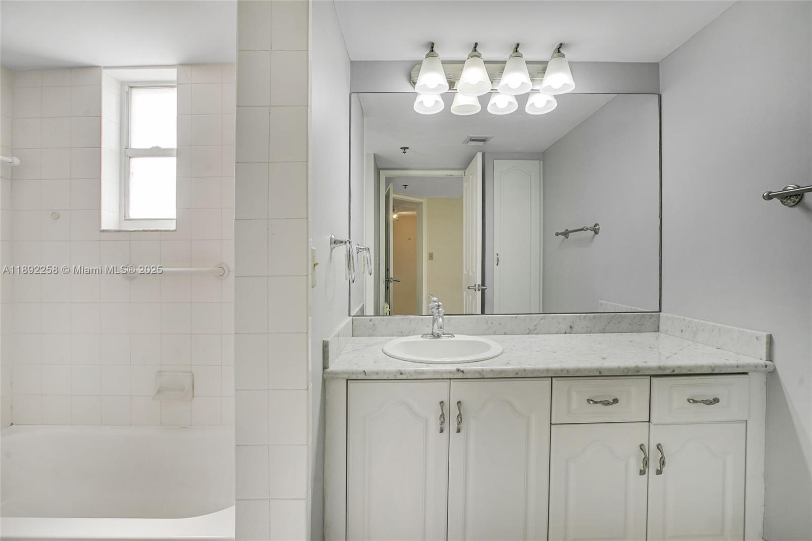 2351 Douglas Road, Unit 604 Miami, FL 33145 - Photo 14 of 26 a bathroom with a granite countertop sink a mirror and a vanity