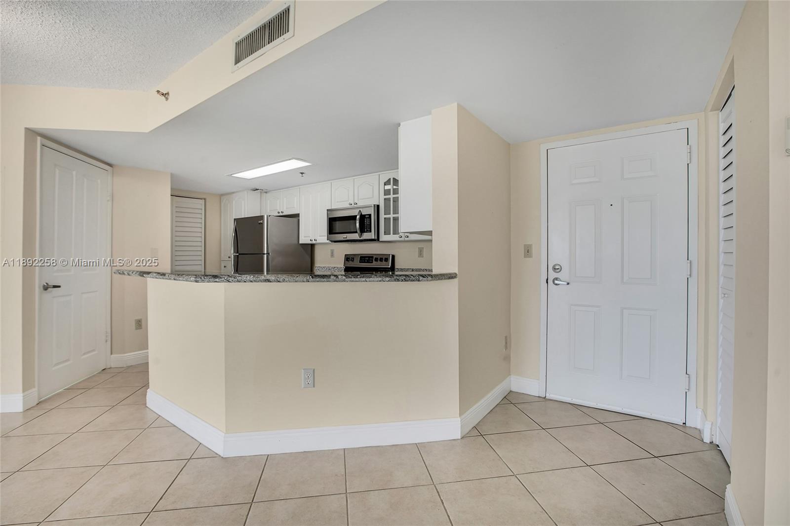 2351 Douglas Road, Unit 604 Miami, FL 33145 - Photo 8 of 26 a kitchen with stainless steel appliances a refrigerator and white cabinets