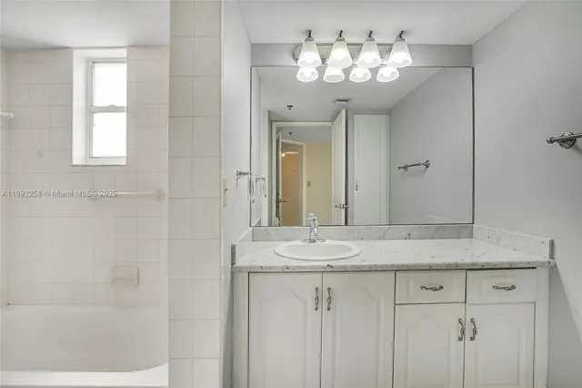 a bathroom with a granite countertop sink a mirror and a vanity