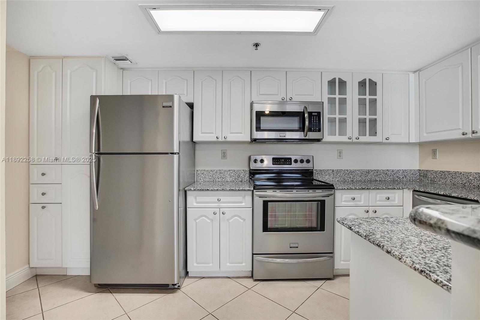 2351 Douglas Road, Unit 604 Miami, FL 33145 - Photo 9 of 26 a kitchen with stainless steel appliances granite countertop a refrigerator stove a sink and a microwave