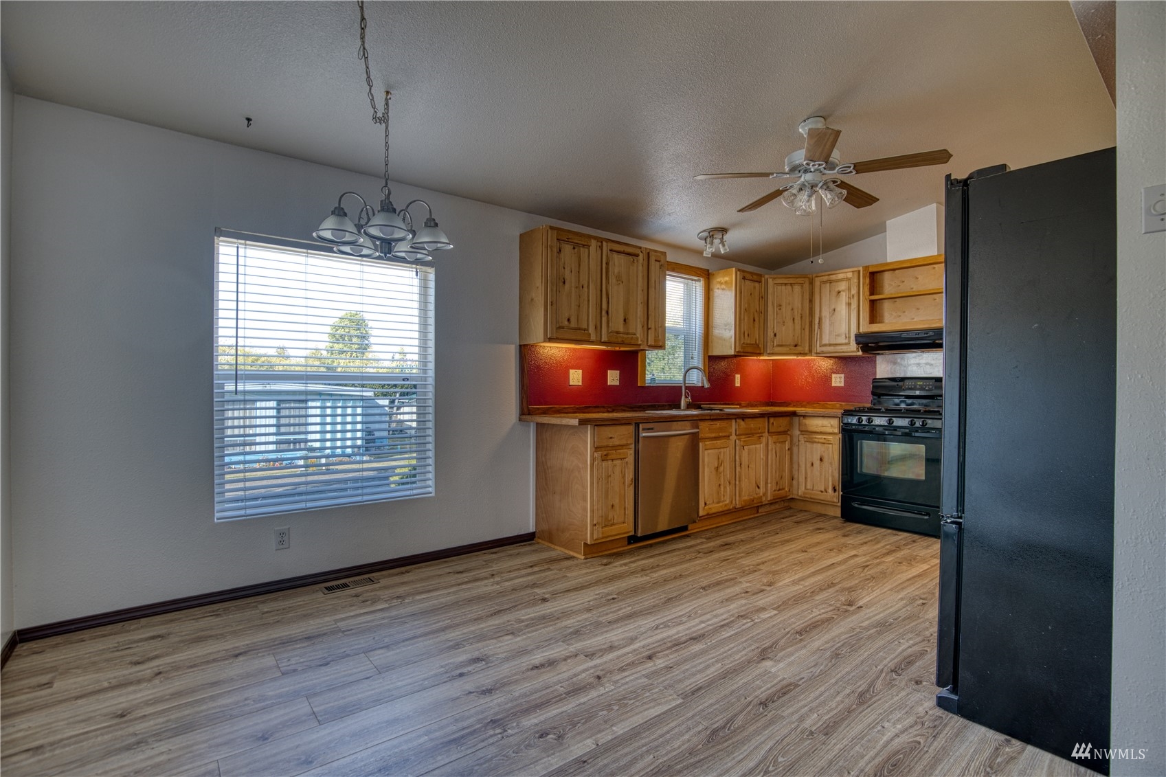 1019 Stanford Drive, Unit 26 Cosmopolis, WA 98537 - Photo 7 of 20 a kitchen with stainless steel appliances a window and wooden floors