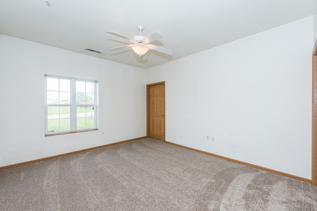 6739 Meadowlands Circle, Unit 6A Pleasant Prairie, WI 53158 - Photo 15 of 19 an empty room with windows and fan