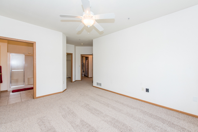 6739 Meadowlands Circle, Unit 6A Pleasant Prairie, WI 53158 - Photo 16 of 19 an empty room with a ceiling fan and a window