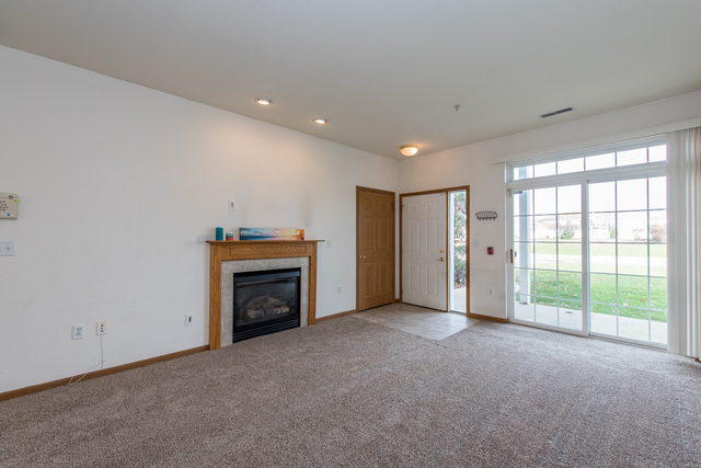 6739 Meadowlands Circle, Unit 6A Pleasant Prairie, WI 53158 - Photo 3 of 19 a view of an empty room with a fireplace and a window