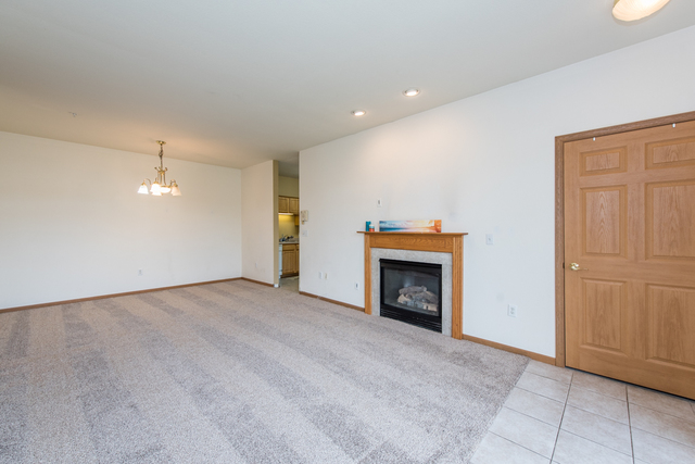 6739 Meadowlands Circle, Unit 6A Pleasant Prairie, WI 53158 - Photo 4 of 19 an empty room with fireplace and window