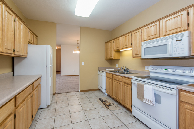 6739 Meadowlands Circle, Unit 6A Pleasant Prairie, WI 53158 - Photo 6 of 19 a kitchen with stainless steel appliances granite countertop a sink and cabinets
