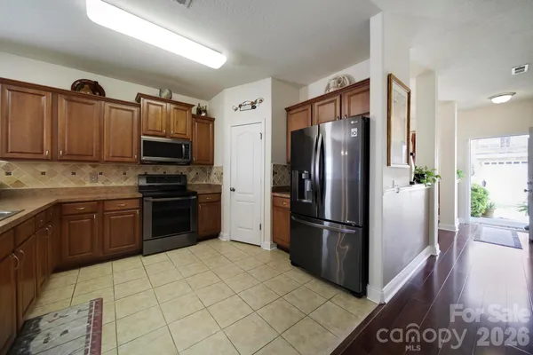 a kitchen with stainless steel appliances granite countertop a refrigerator stove and sink