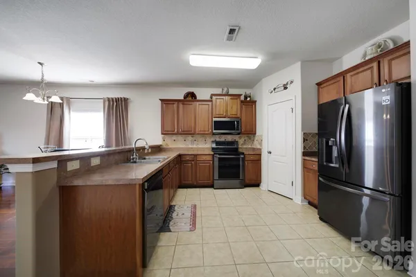 a kitchen with kitchen island a refrigerator sink and cabinets