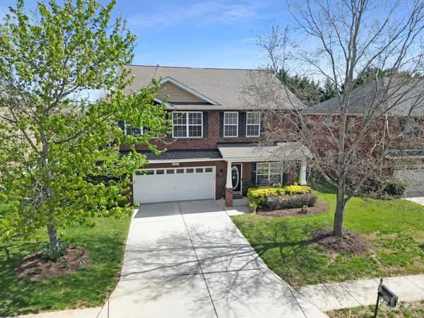 a view of house with garden and tall trees