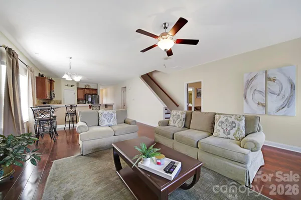 a living room with furniture and a view of kitchen