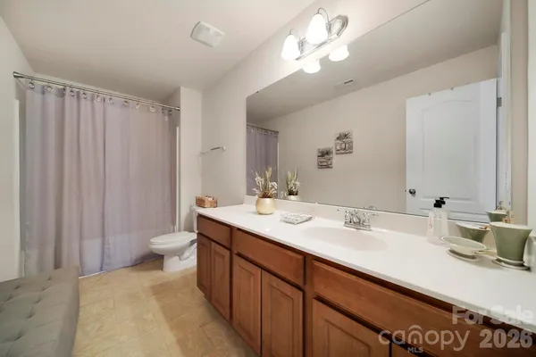a bathroom with a sink a toilet and large mirror
