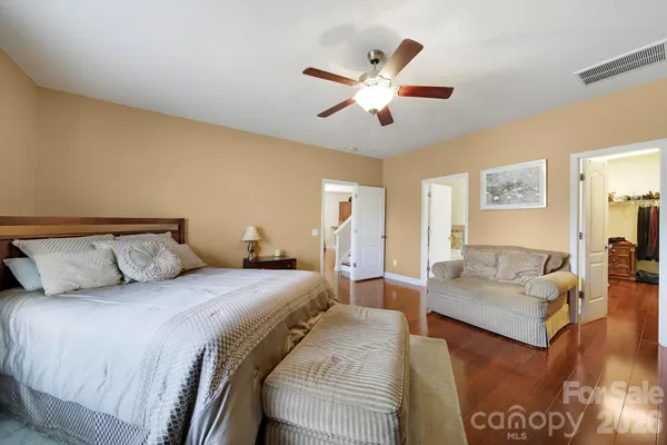 a bedroom with a large bed and a chandelier