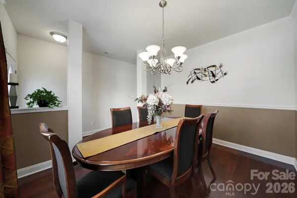 a view of a dining room with furniture a chandelier and wooden floor