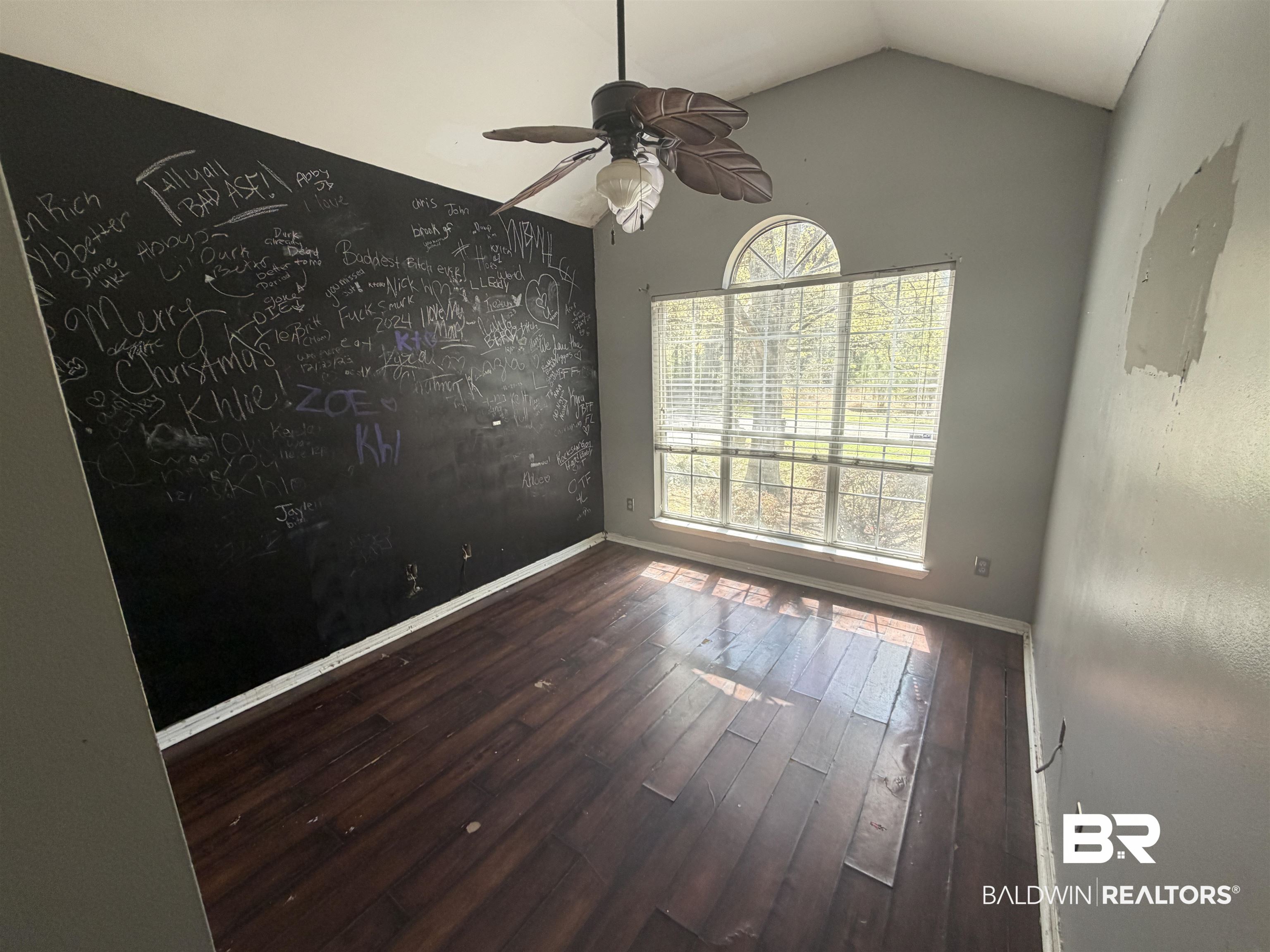 7067 Pinehill Road Daphne, AL 36526 - Photo 11 of 18 Spare room featuring ceiling fan, an accent wall, and dark wood-type flooring